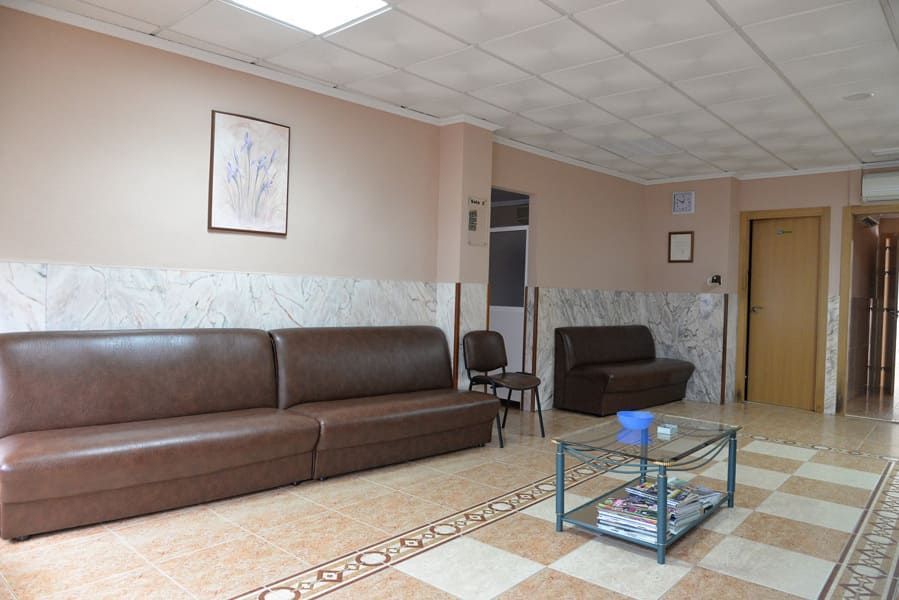 Una sala de espera con un sofá y una mesa de café