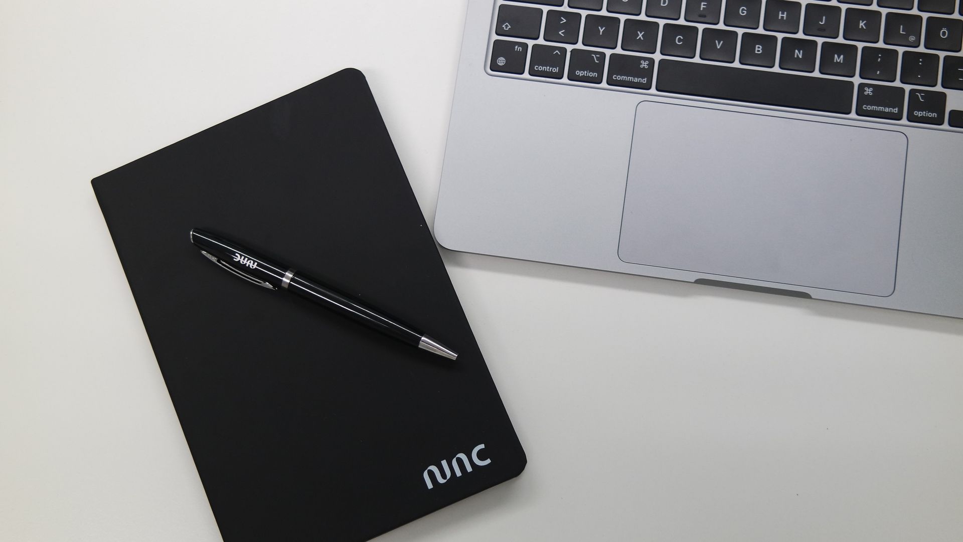 Nahaufnahme von einem Laptop, Notizbuch und Kugelschreiber