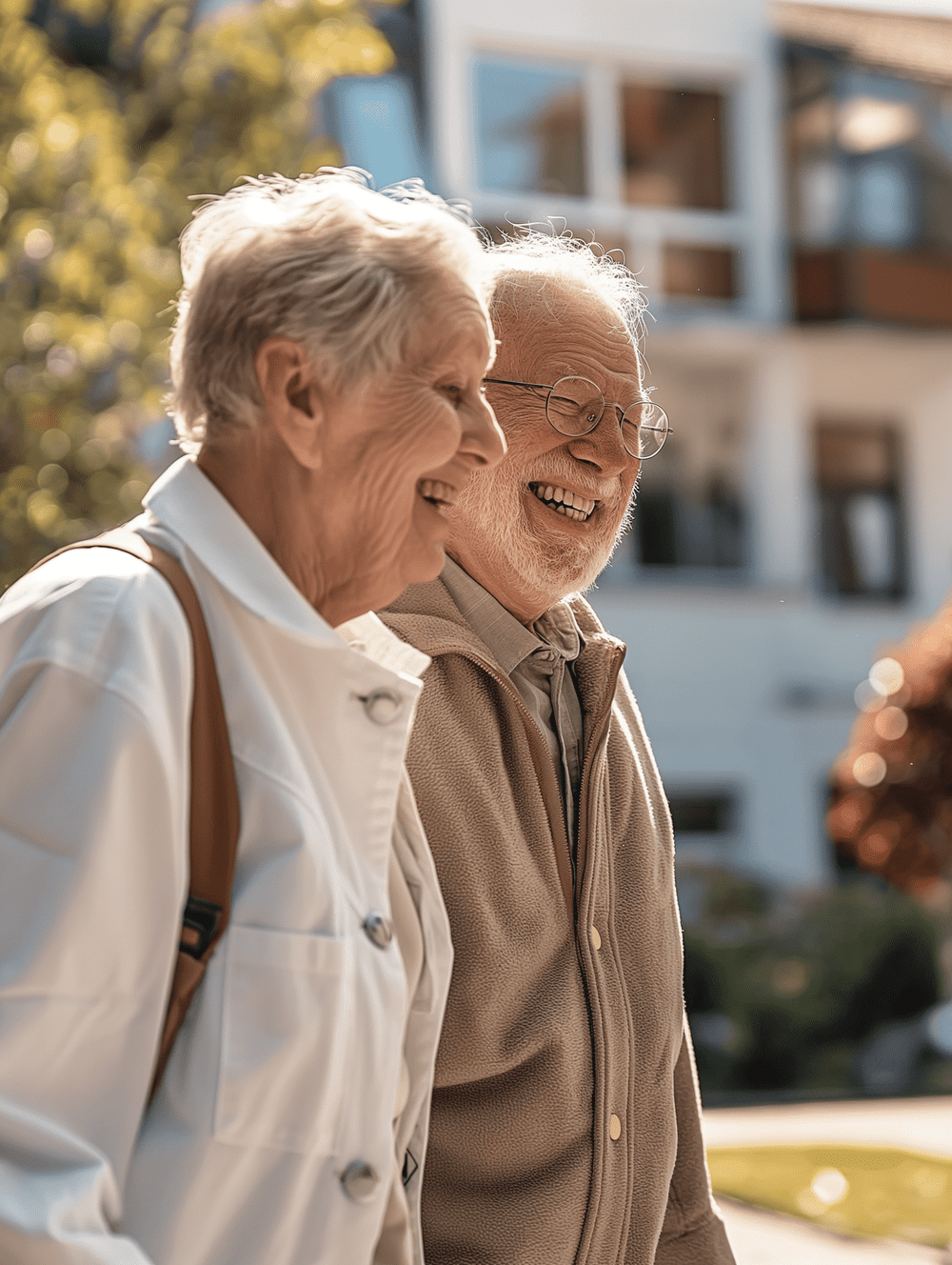 Ein älteres Ehepaar geht gemeinsam die Straße entlang und lächelt.