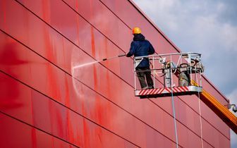 CB Renovation & Reinigung Service – Maler reinigt eine rote Hausfassade