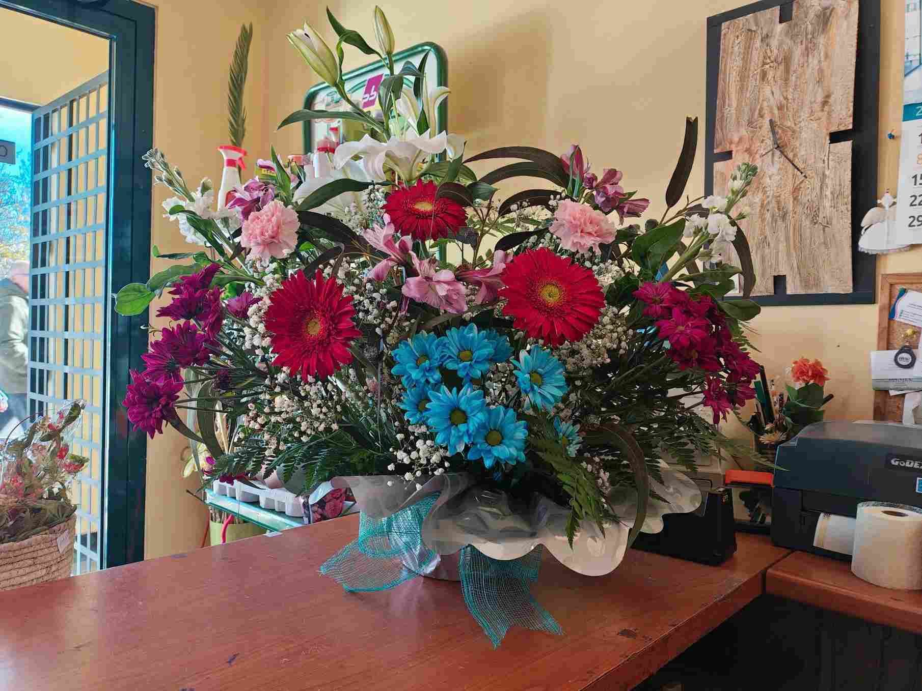 Un vistoso ramo de flores variadas en un jarrón sobre una mesa de madera