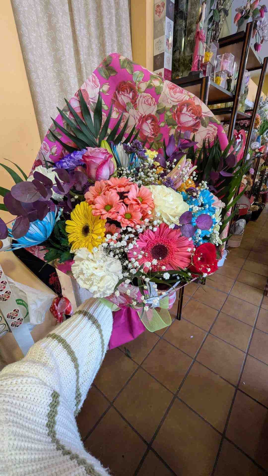 Ramo de mano con flores variadas y coloridas, que incluyen flores rosas