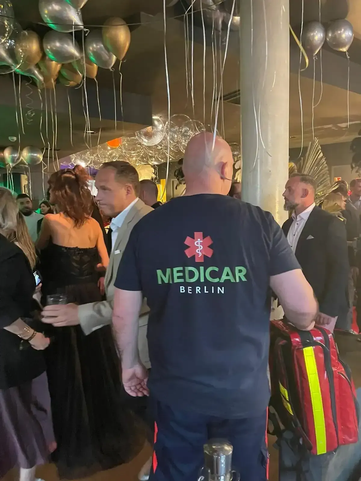 Ein Mann in einem Sanitäterhemd steht in einer Menschenmenge