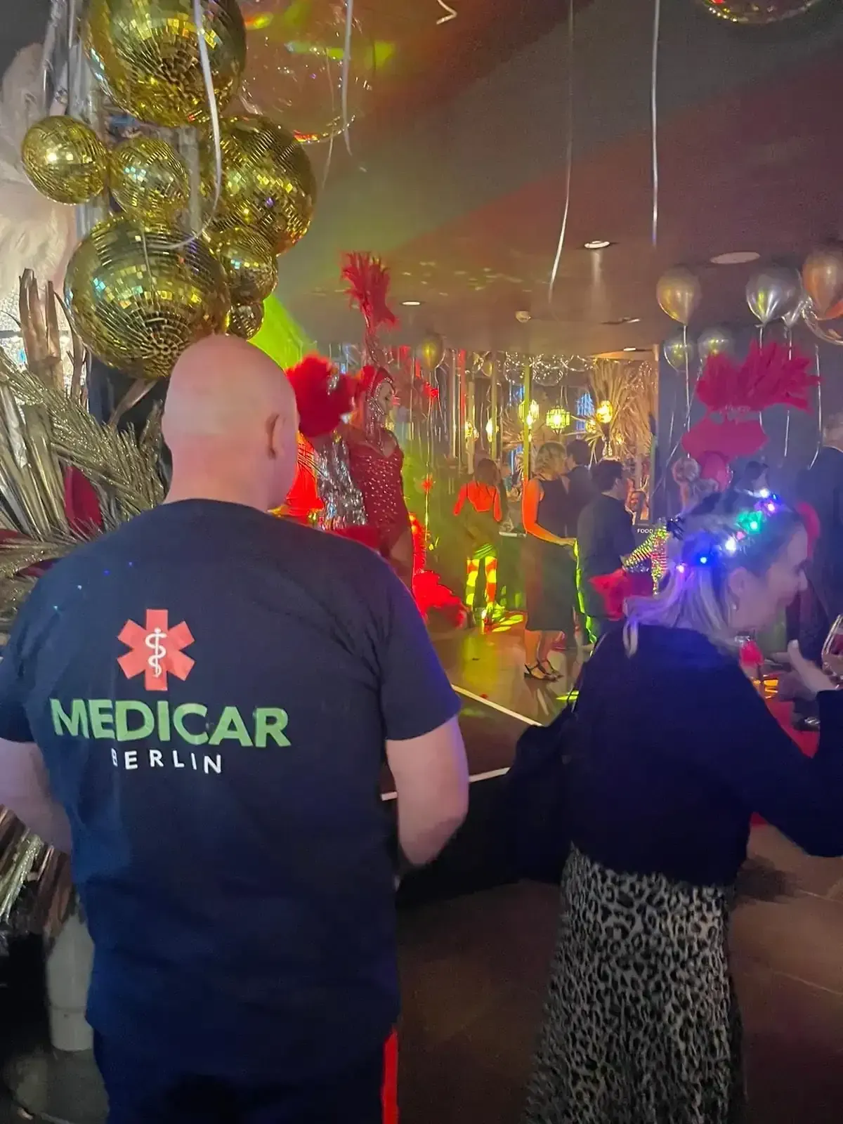 Ein Mann in einem Sanitäterhemd steht neben einer Frau