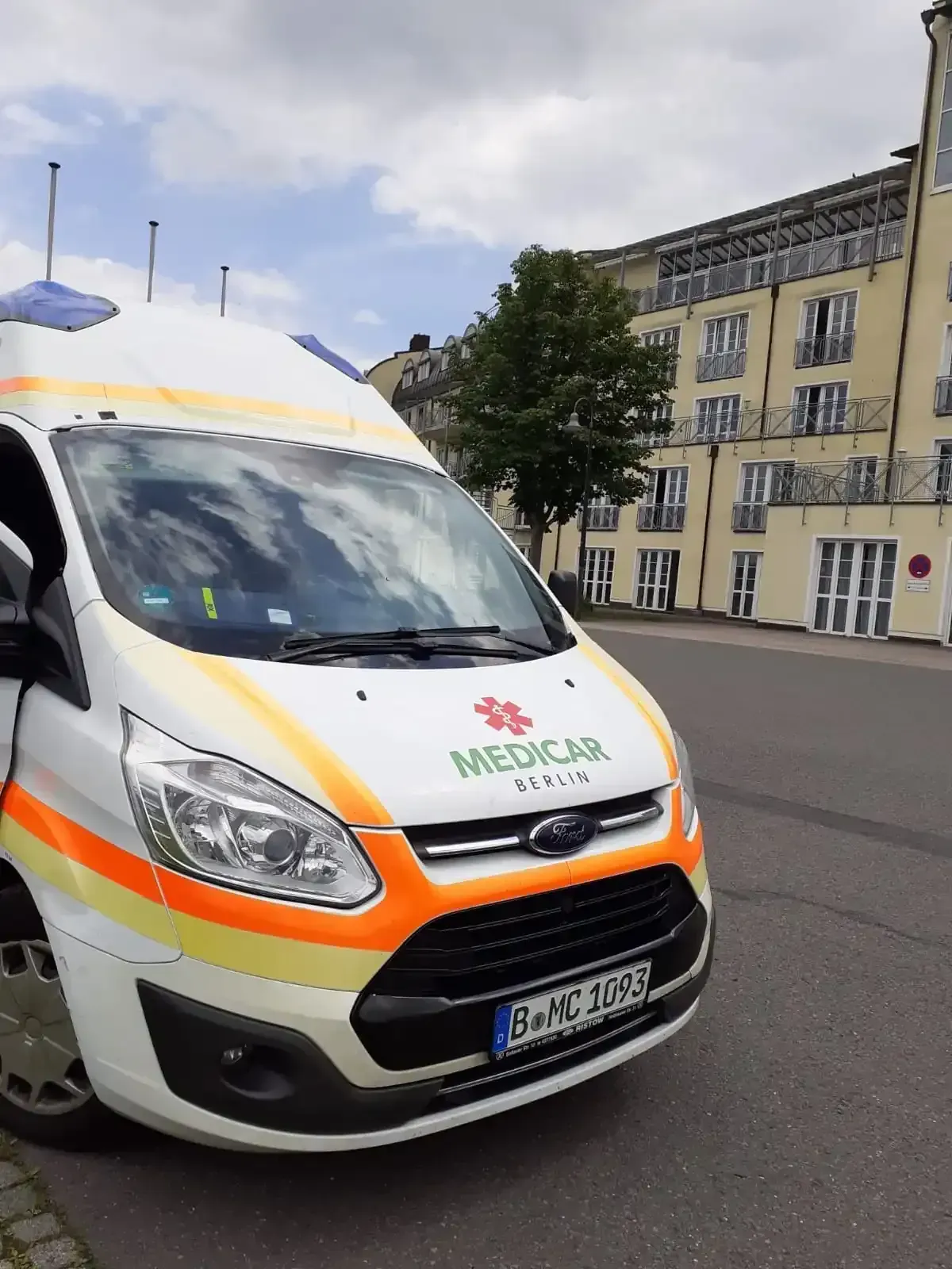 Ein Krankenwagen steht am Straßenrand vor einem Gebäude.