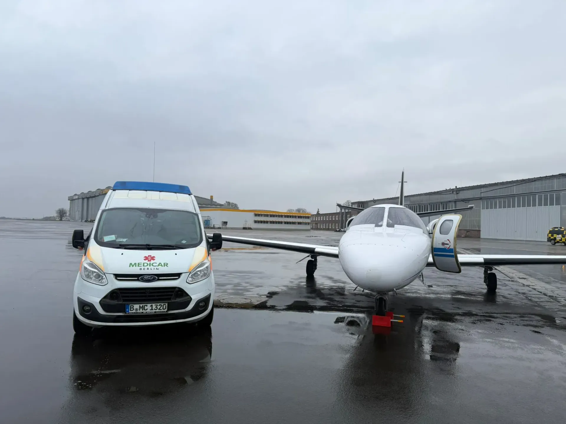 Ein weißer Lieferwagen steht neben einem kleinen Flugzeug