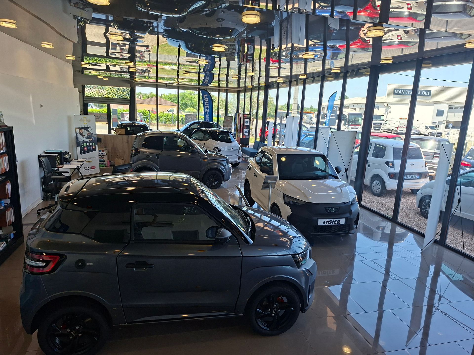 Salle d'exposition d'un concessionnaire automobile avec plusieurs voitures garées.
