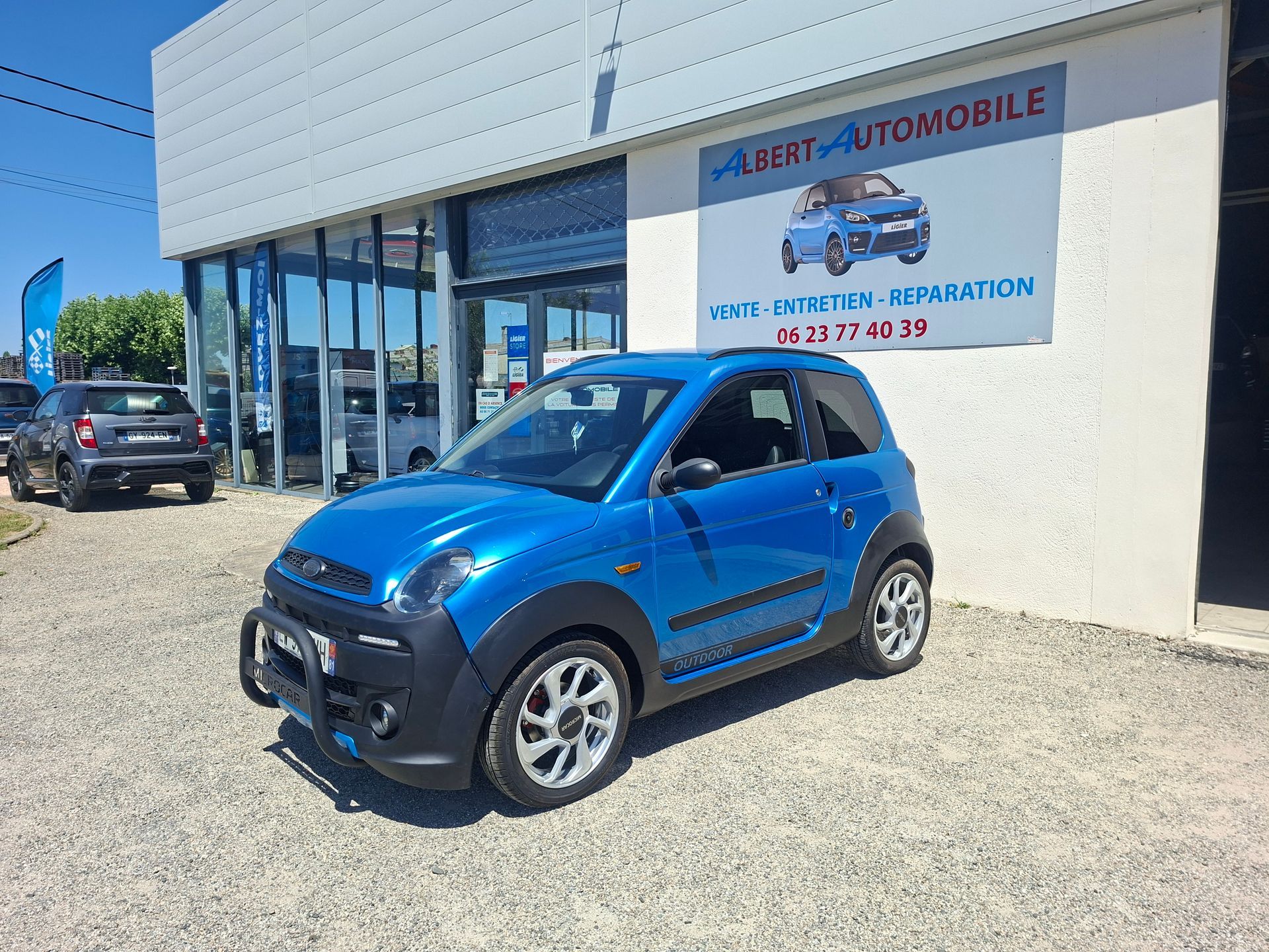 Voiture compacte garée devant un garage.
