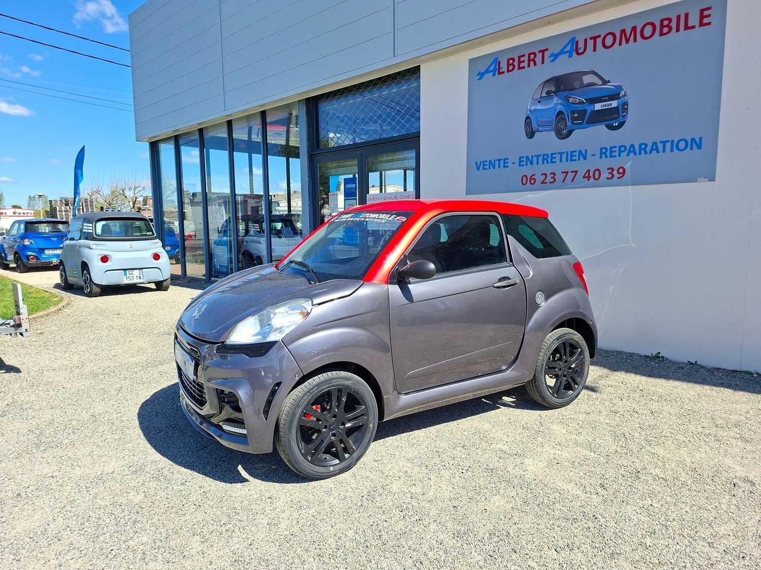 Voiture compacte garée devant un garage.