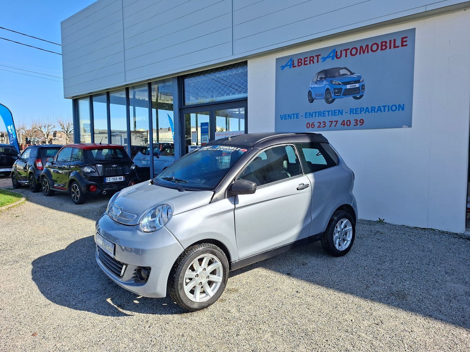 Voiture Smart garée devant une concession de voitures d'occasion.