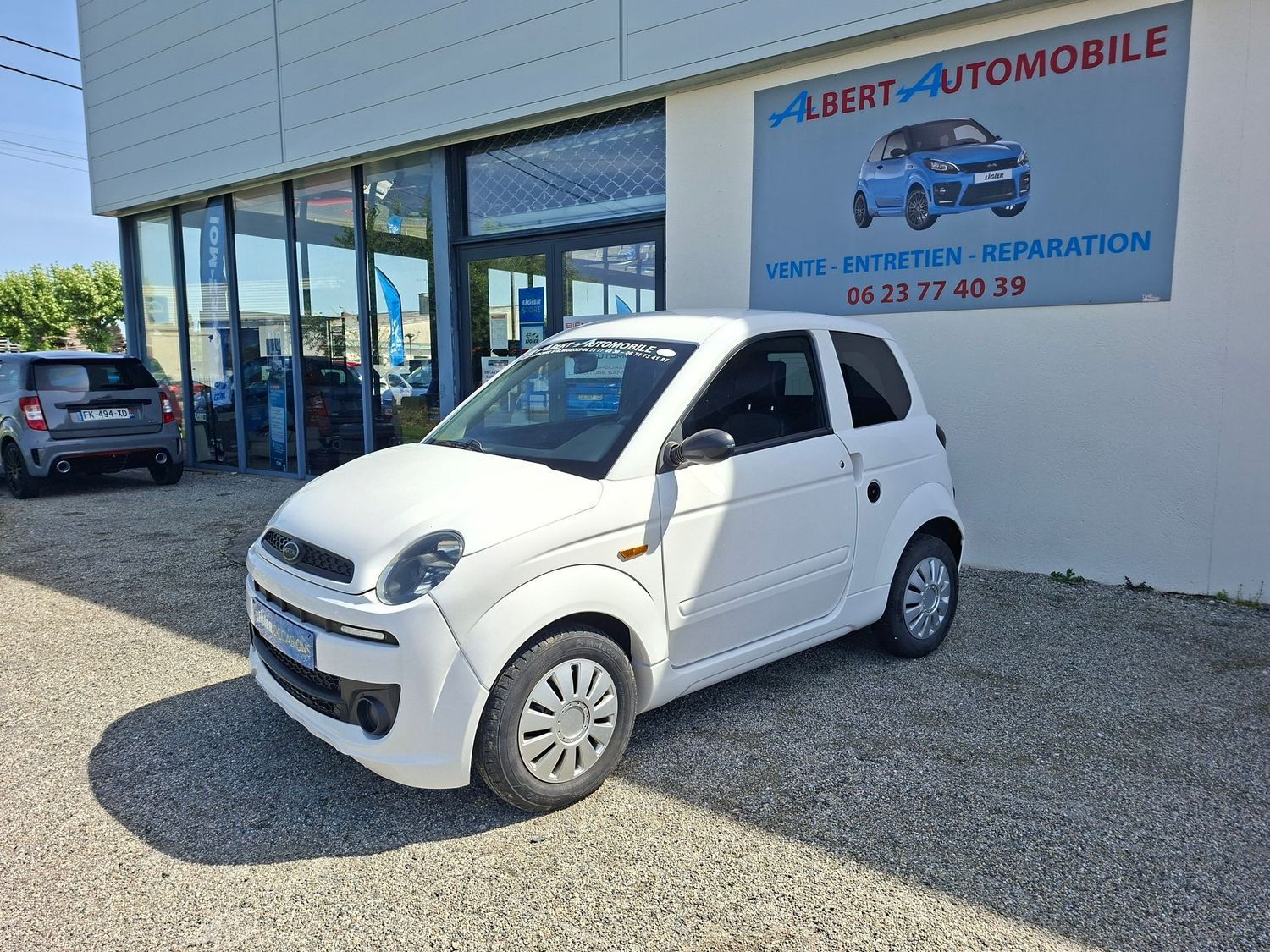 Voiture compacte garée devant un garage.