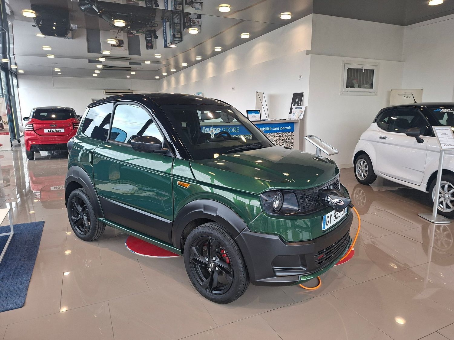 Voiture compacte verte dans une salle d'exposition.