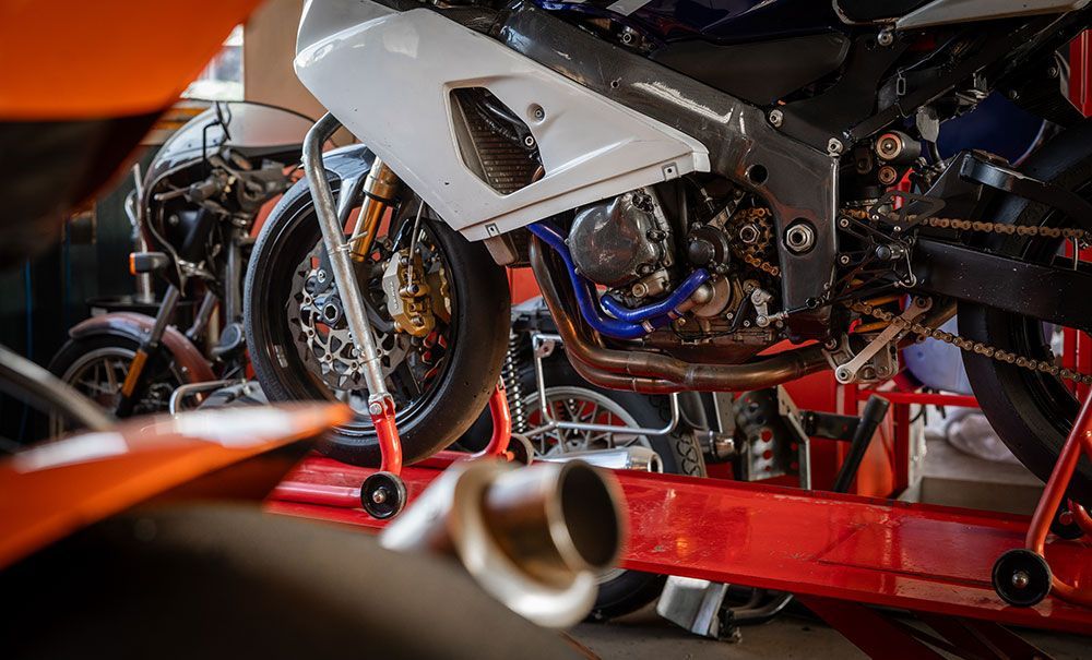 In einer Garage wird an einem Motorrad gearbeitet.