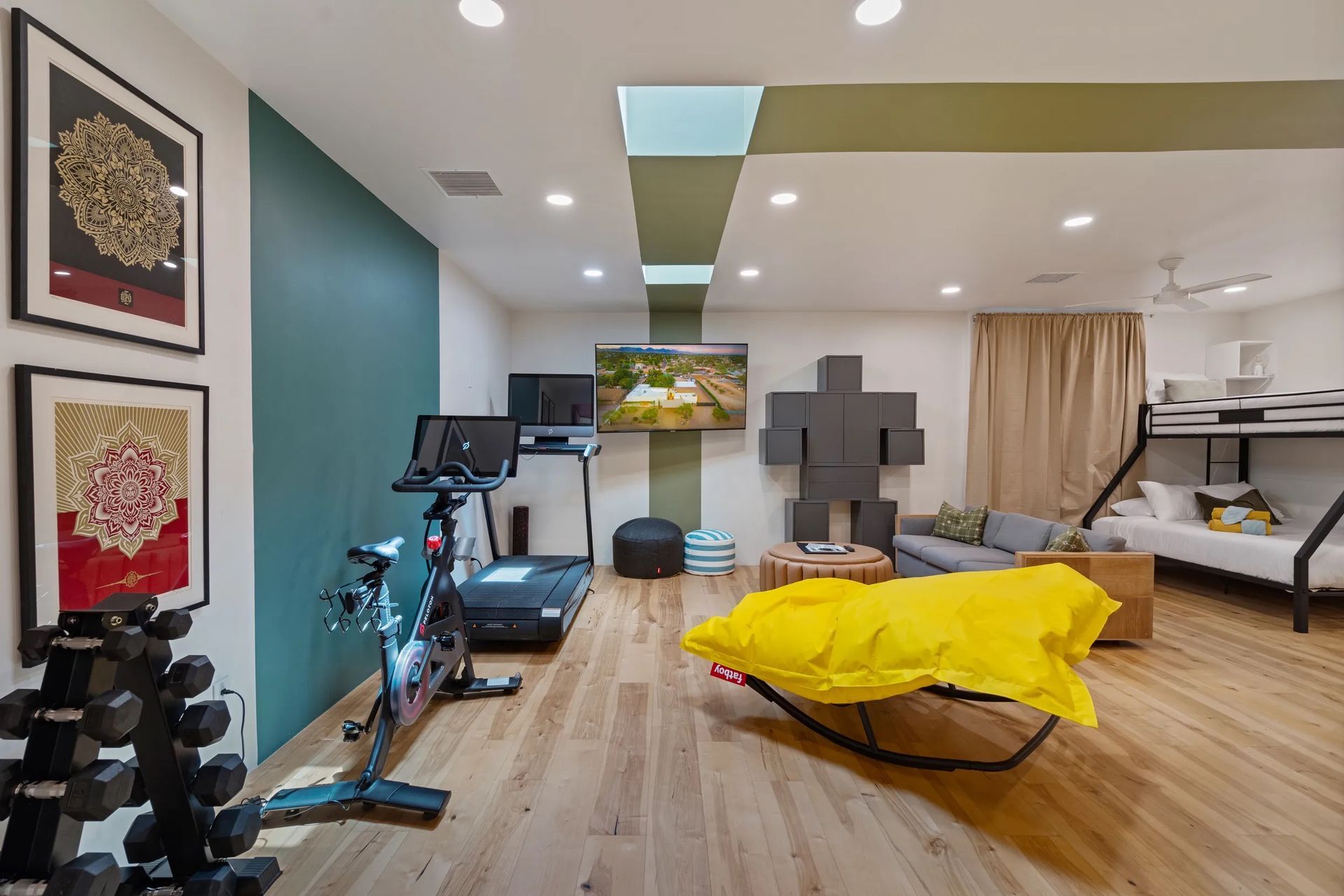 Home gym and recreation room with exercise equipment, bunk beds, and a large bean bag chair.