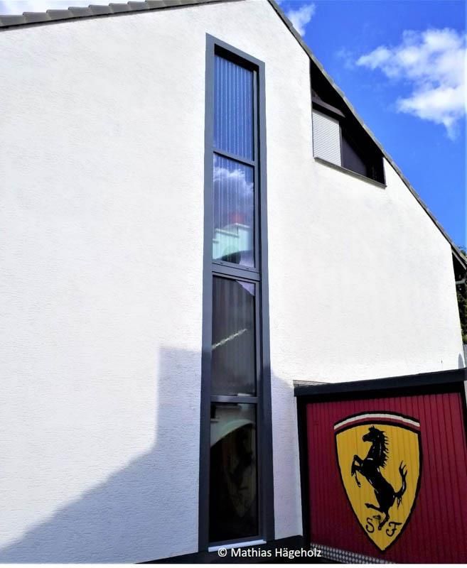 Ein weißes Gebäude mit einem roten Schild mit der Aufschrift Ferrari