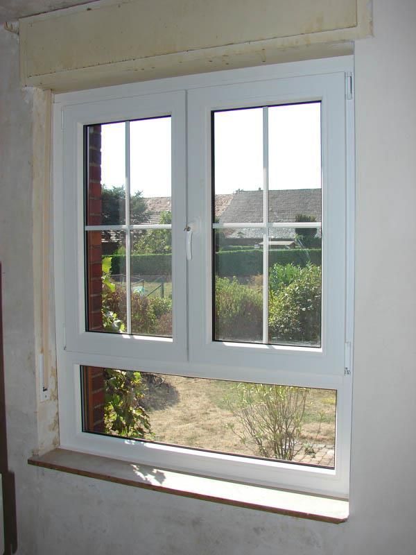 Ein weißes Fenster mit einer Backsteinmauer dahinter