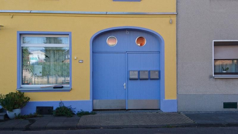 Ein gelb-blaues Gebäude mit einer blauen Tür