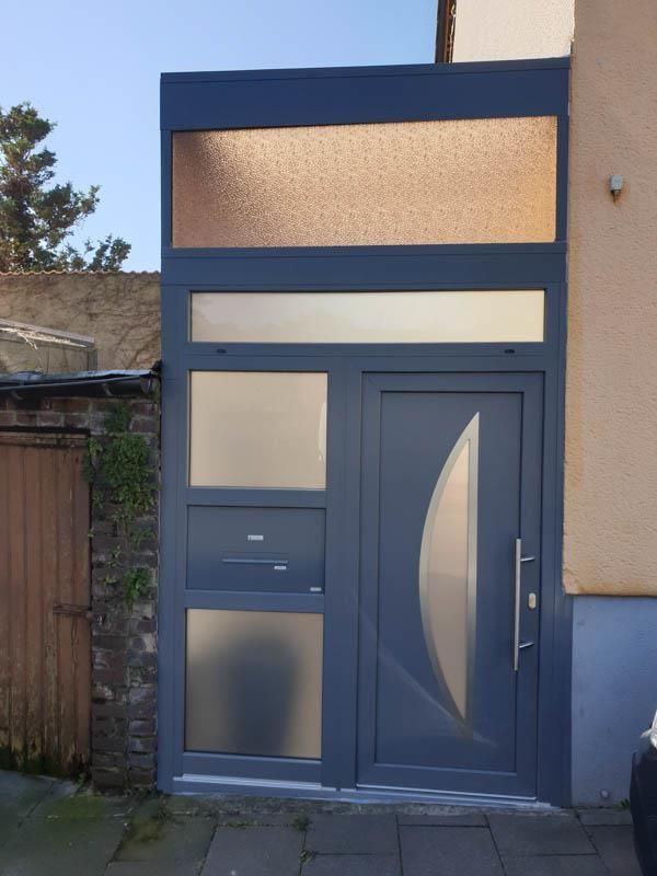 Eine graue Tür mit einem Edelstahlgriff