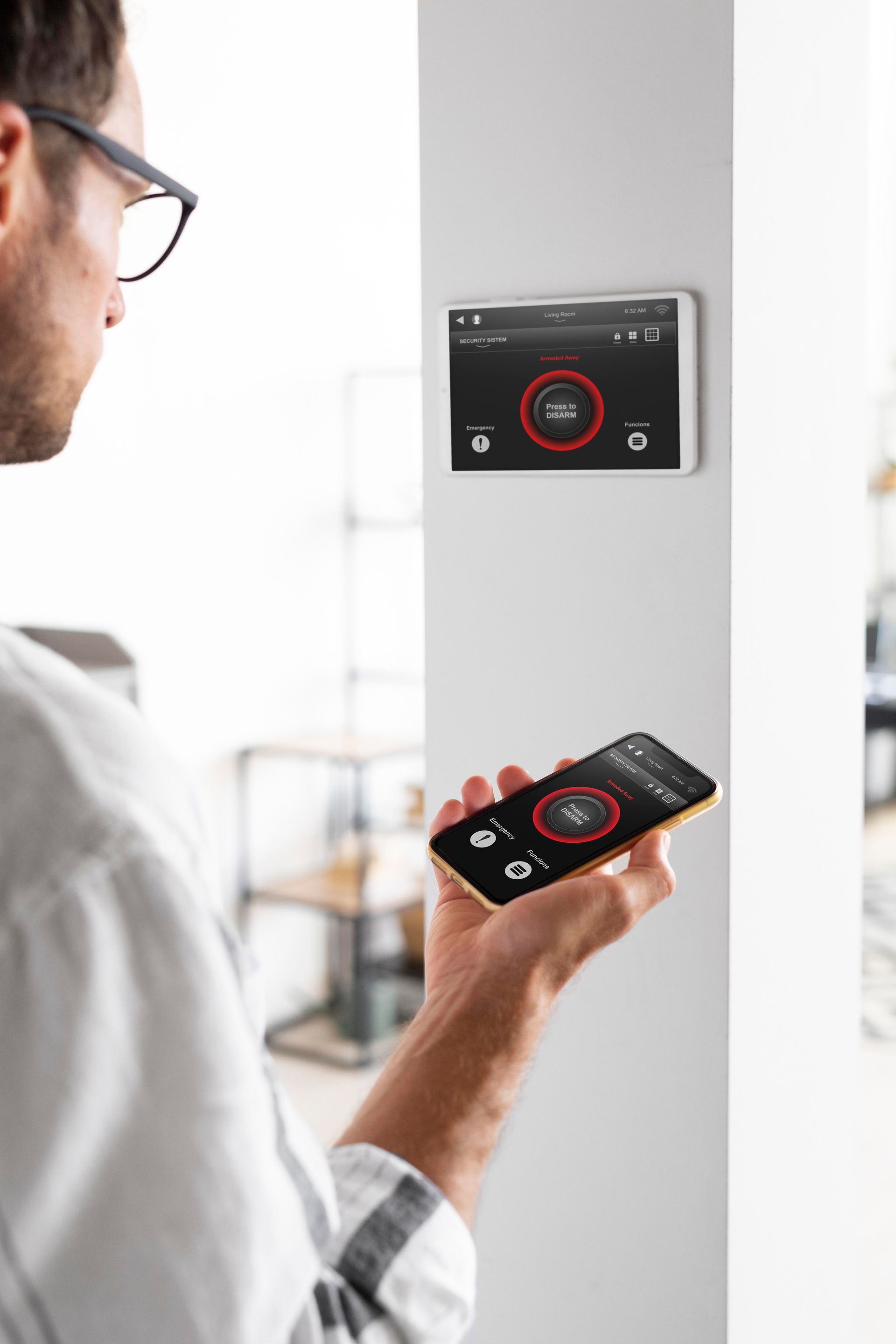 Persona que utiliza un teléfono inteligente para controlar un termostato de pared o un panel de control domótico.