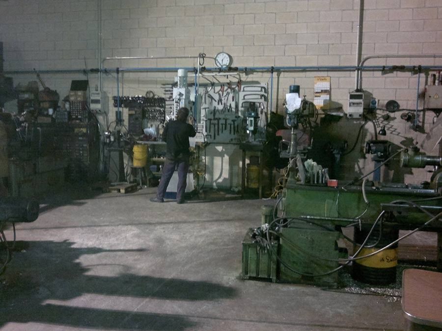 Un hombre está trabajando en una máquina en una fábrica.