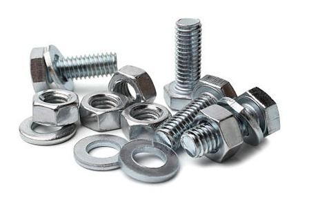 Una pila de tuercas y tornillos sobre un fondo blanco.