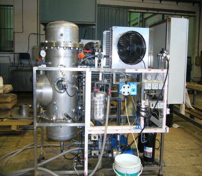 Un hombre que lleva un casco escribe en un portapapeles en una fábrica.