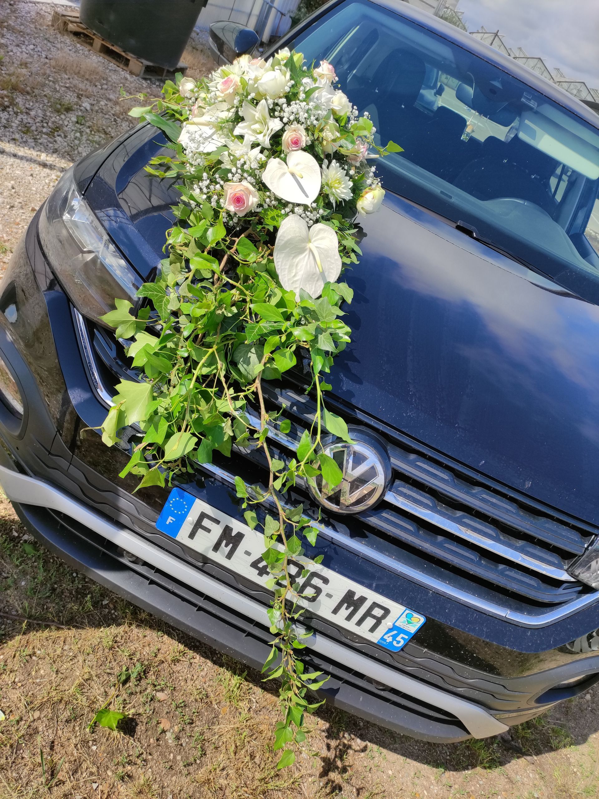 Une voiture noire avec des fleurs.