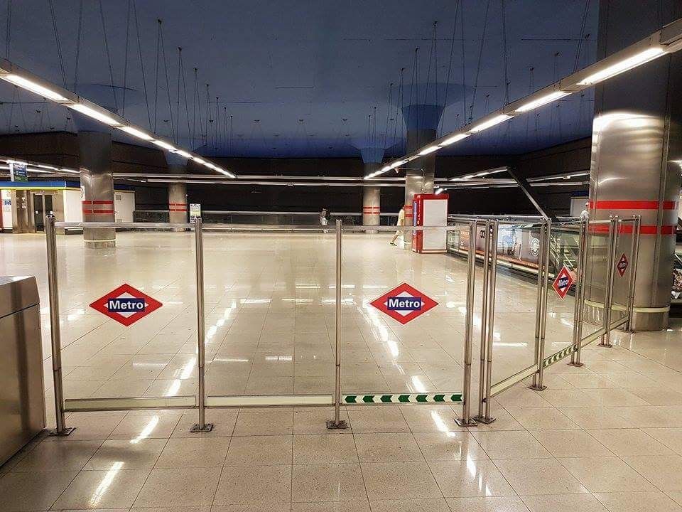 Interior de una estación de metro con barreras de cristal y el logo del Metro.