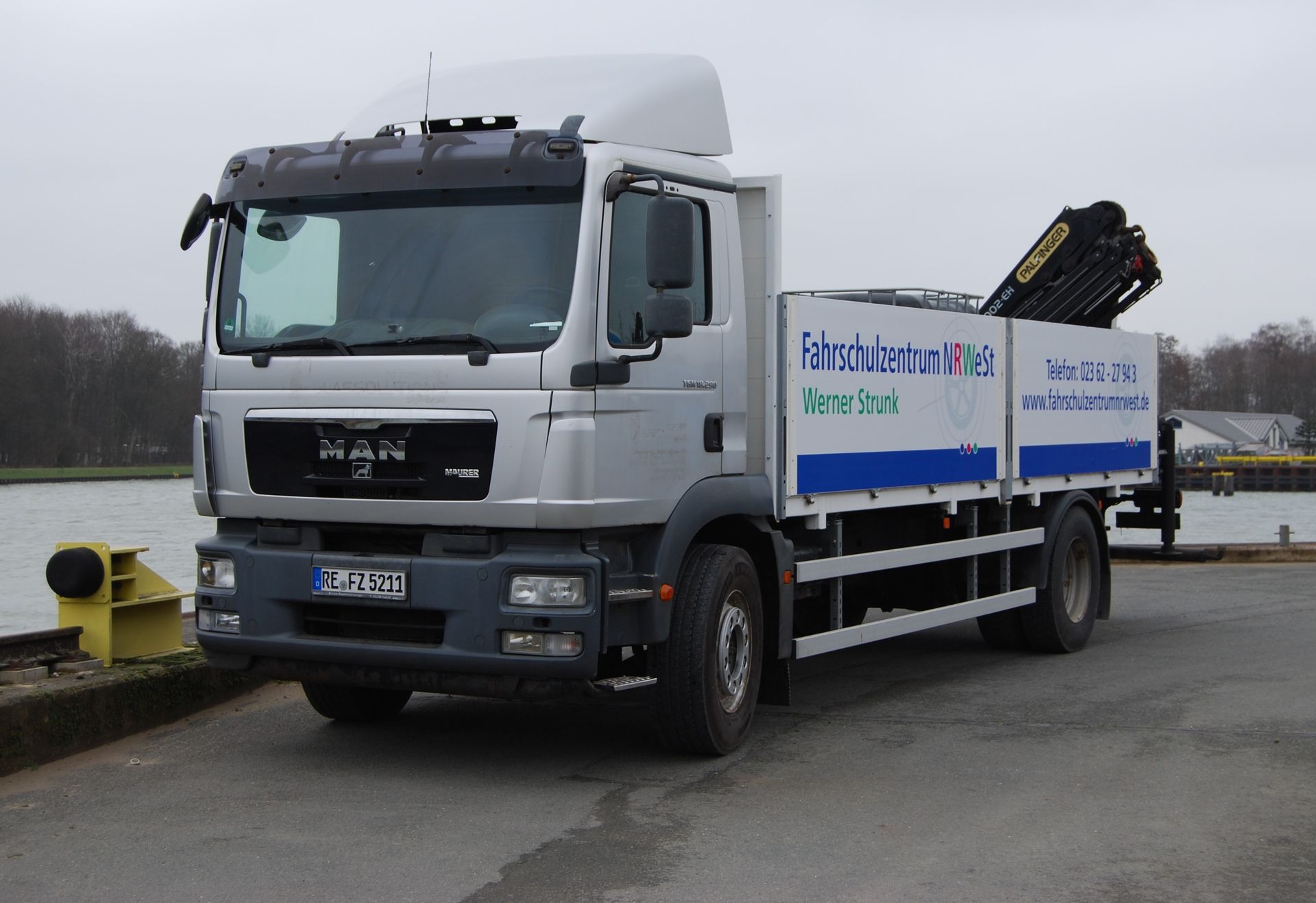 Ein Mann-LKW ist neben einem Gewässer geparkt