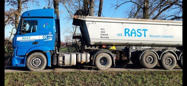 Ein blauer Lastwagen mit dem Logo „Rast“ an der Seite