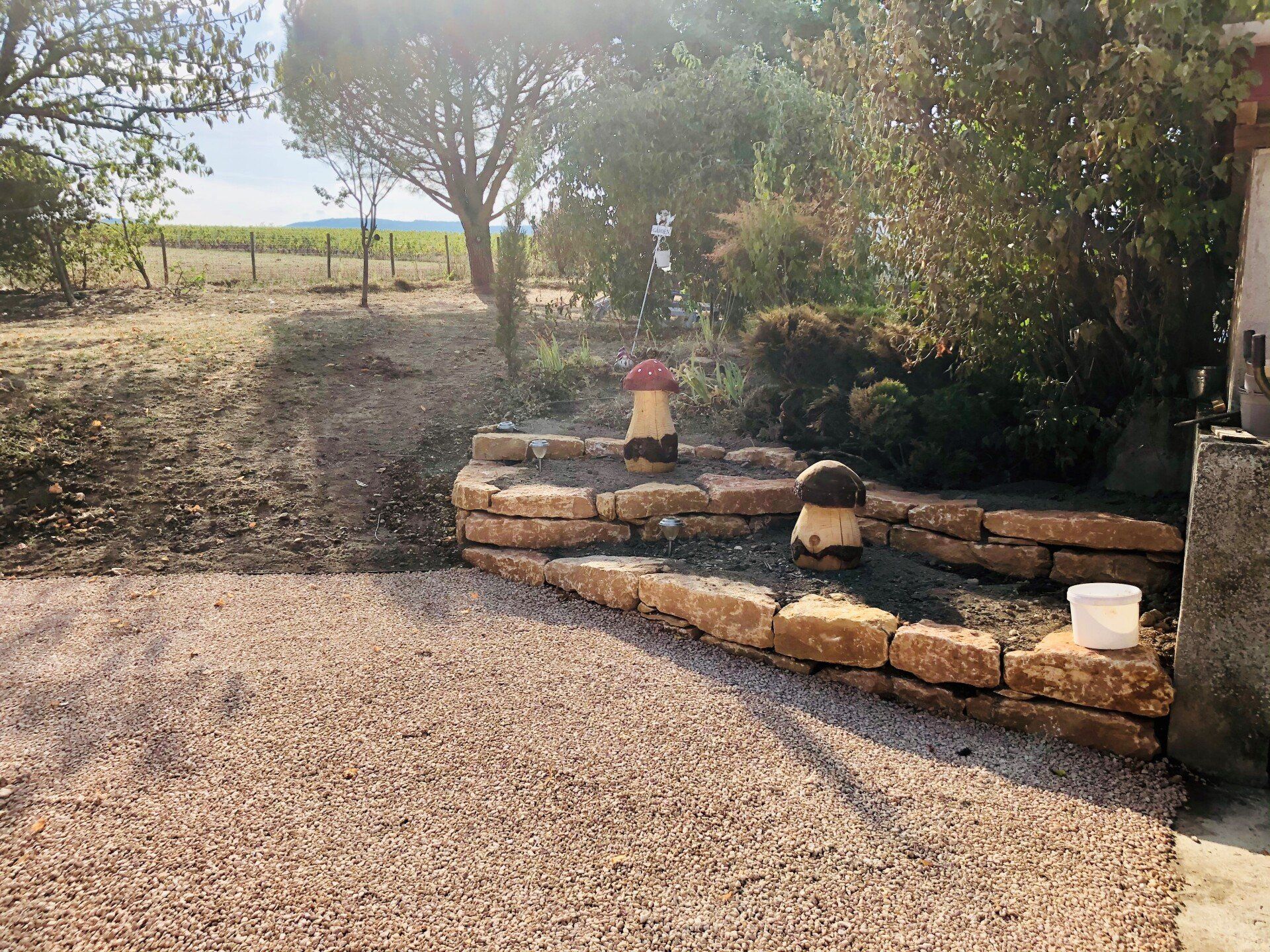 Enrochement et gravillonnage en pierre dorée de l'extérieur d'une maison individuelle