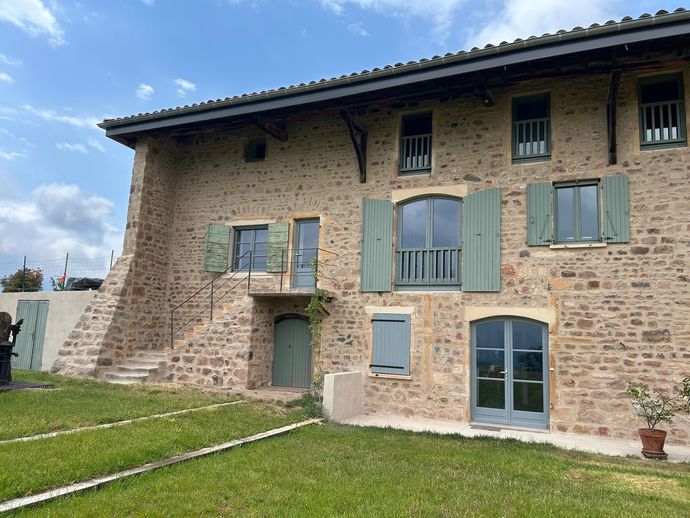 Façade d'une grande maison en pierre dorée après rénovation