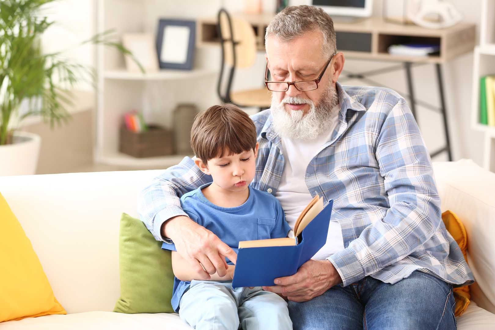 Un petit garçon avec son grand-père lit un livre