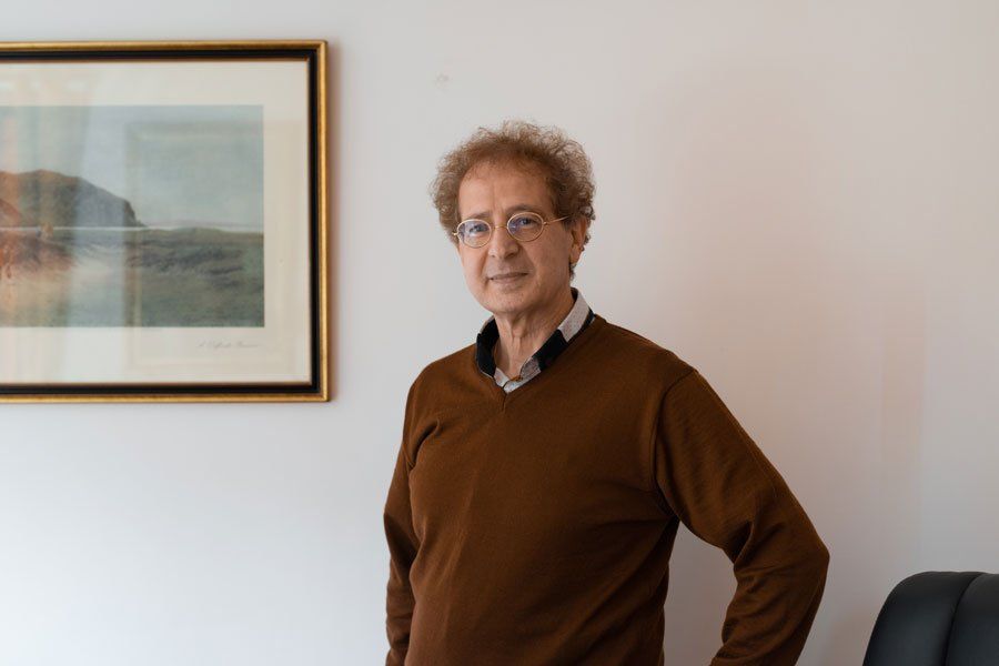 Maître Henry Mons se tient debout à côté d'un tableau