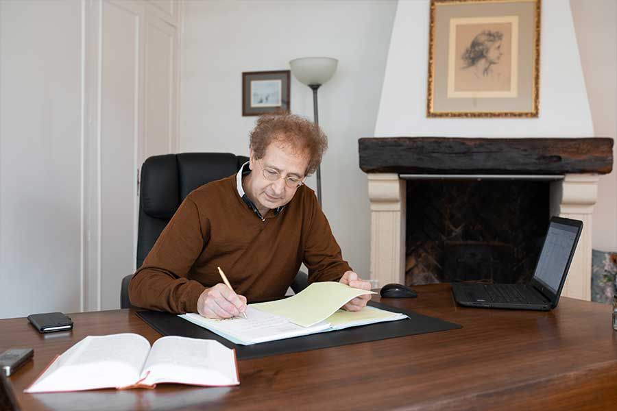 Maître Henry Mons assis à son bureau en train d'écrire