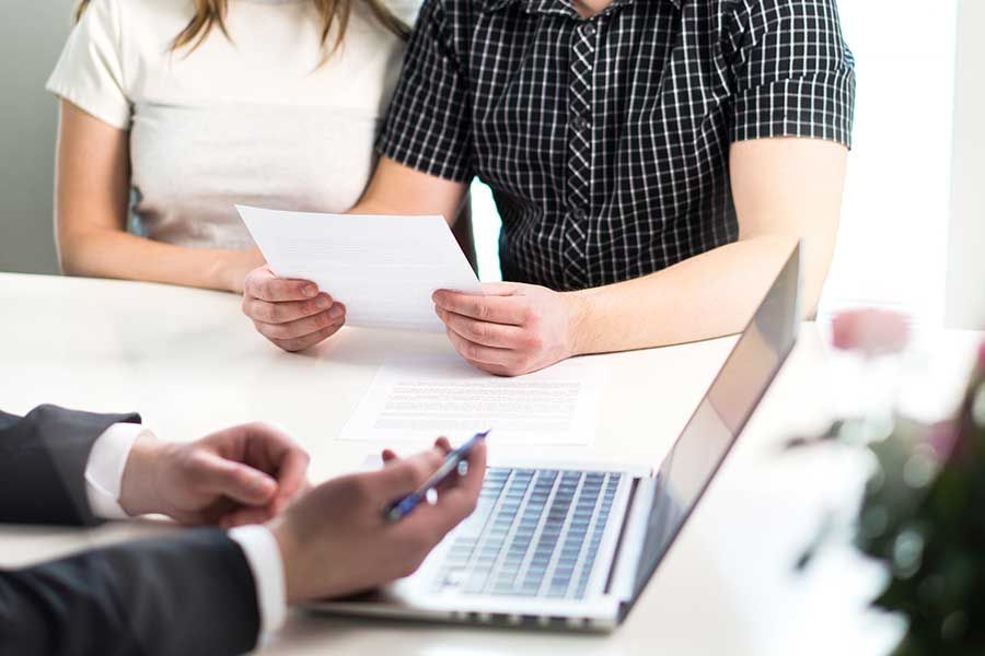 Un couple lit une feuille devant un avocat