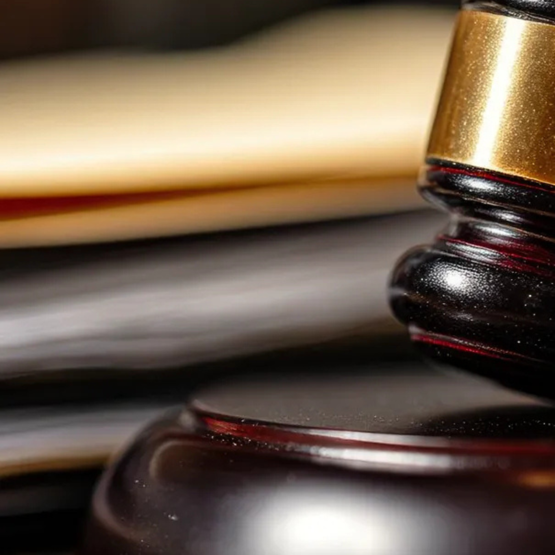 Un maillet de juge en bois repose à côté d'une pile de documents juridiques, avec un logo dans le coin supérieur droit.
