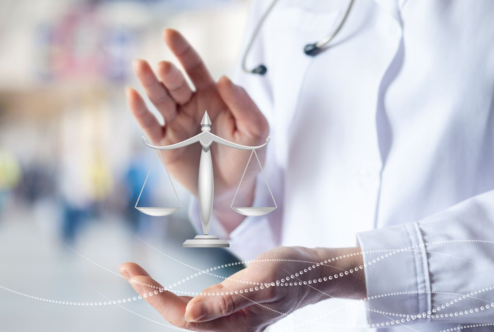 Vers page droit de la santé Les mains d'un médecin tenant une balance, symbolisant l'éthique et la justice médicales.
