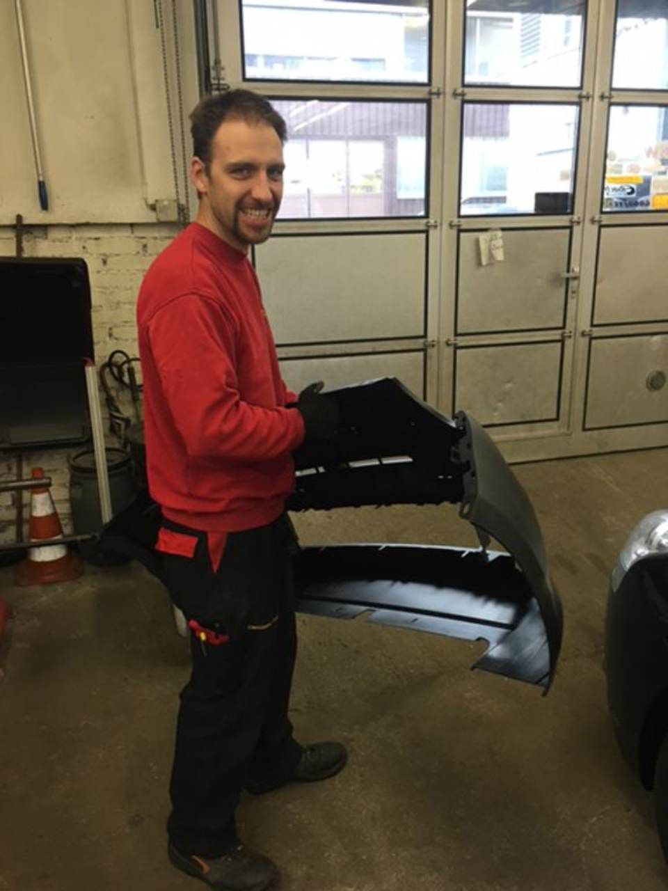 Mitarbeiter der Carrosserie W. Schoch GmbH mit Carrosserieteil