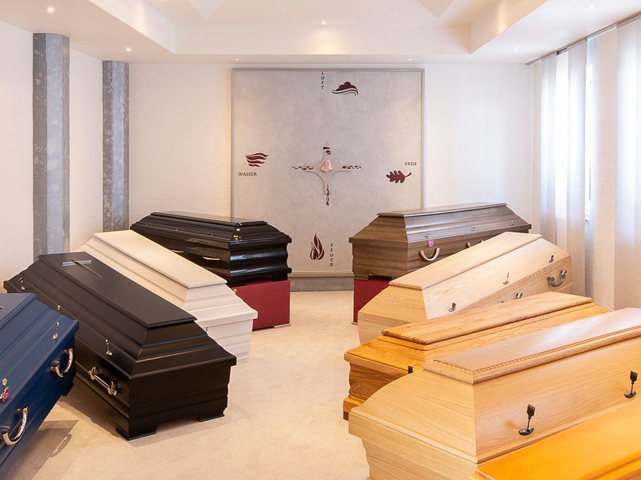 eine Reihe von Totenkisten in einem Raum mit einem Kreuz darauf - Bestattungen Vornholt in Borken