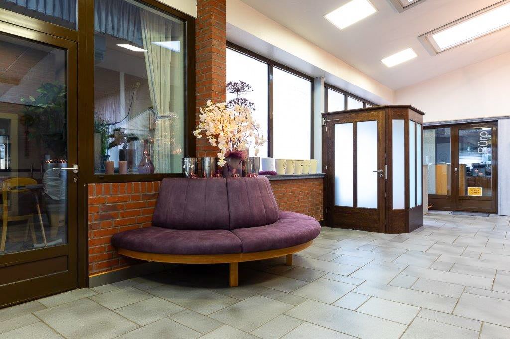 ein Wohnzimmer mit einer lila Bank und vielen Fenstern - Bestattungen Vornholt in Borken-Burlo