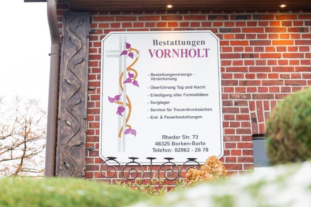 ein Schild an der Seite eines Backsteingebäudes , das vornholt sagt - Bestattungen Vornholt in Borken-Burlo