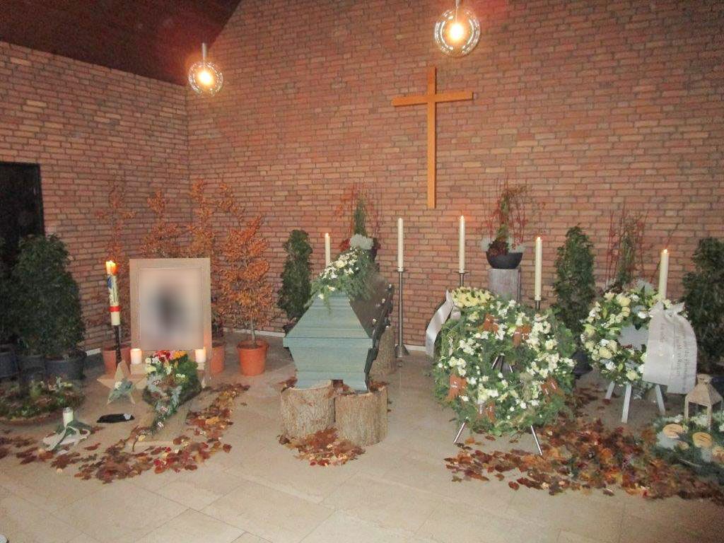 ein Friedhof mit einem Sarg , Blumen und Kerzen - Bestattungen Vornholt in Borken-Burlo