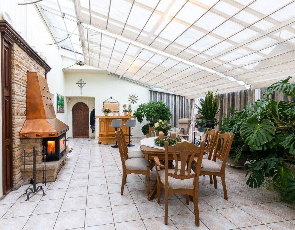 ein großer Raum mit einem Tisch und Stühlen und einem Kamin - Bestattungen Vornholt in Borken-Burlo