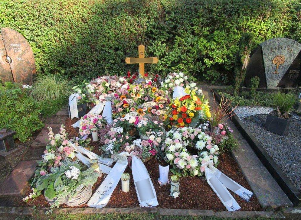 ein Grab mit Blumen und einem Kreuz darauf - Bestattungen Vornholt in Borken-Burlo