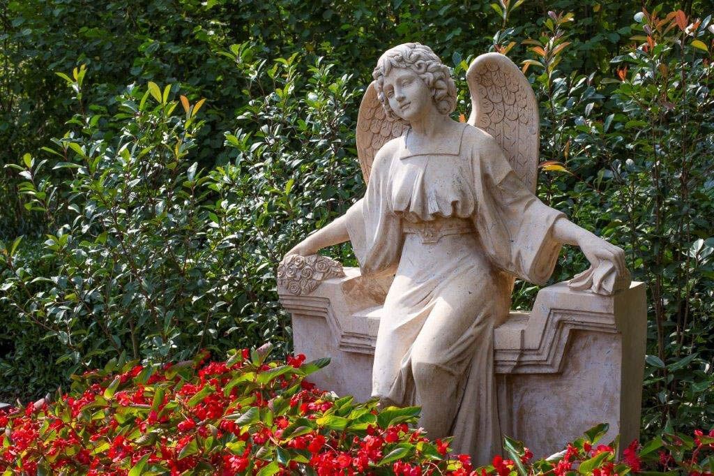 eine Statue eines Engels sitzt auf einem Grabstein - Bestattungen Vornholt in Borken-Burlo