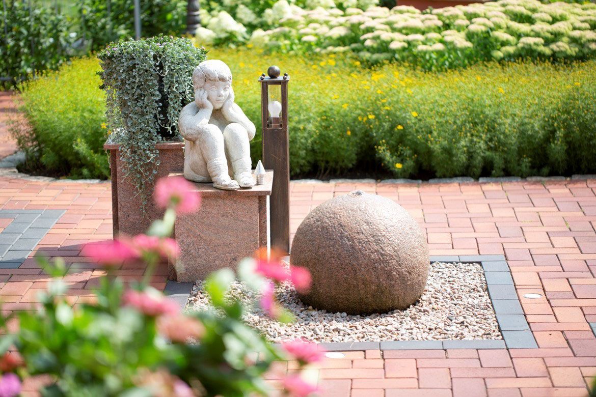 eine Statue eines Mannes , der auf einer Bank sitzt - Bestattungen Vornholt in Borken-Burlo
