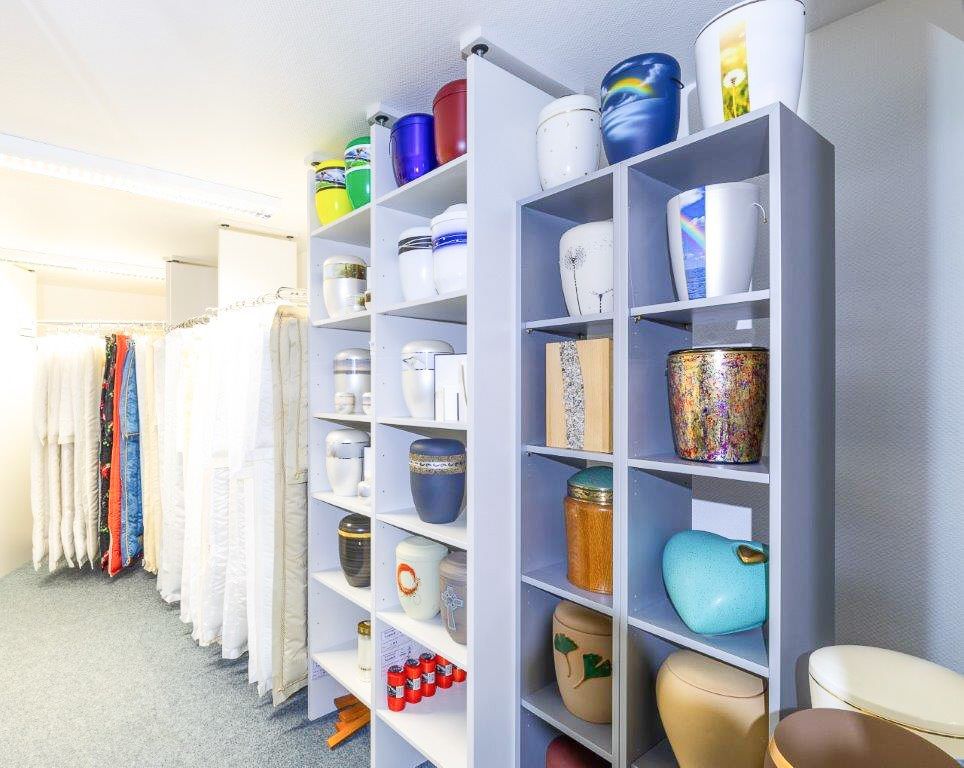 ein Raum mit Regalen voller Urnen in verschiedenen Farben - Bestattungen Vornholt in Borken-Burlo