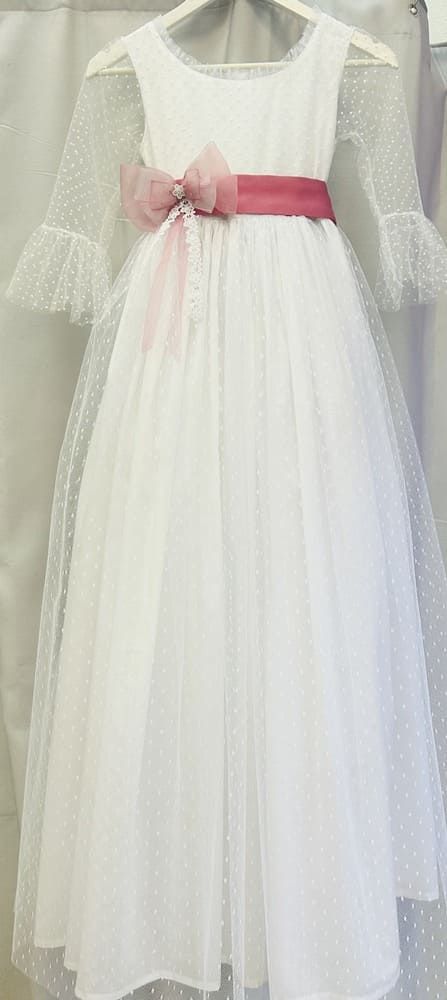Un vestido blanco con una faja azul cuelga de una percha.