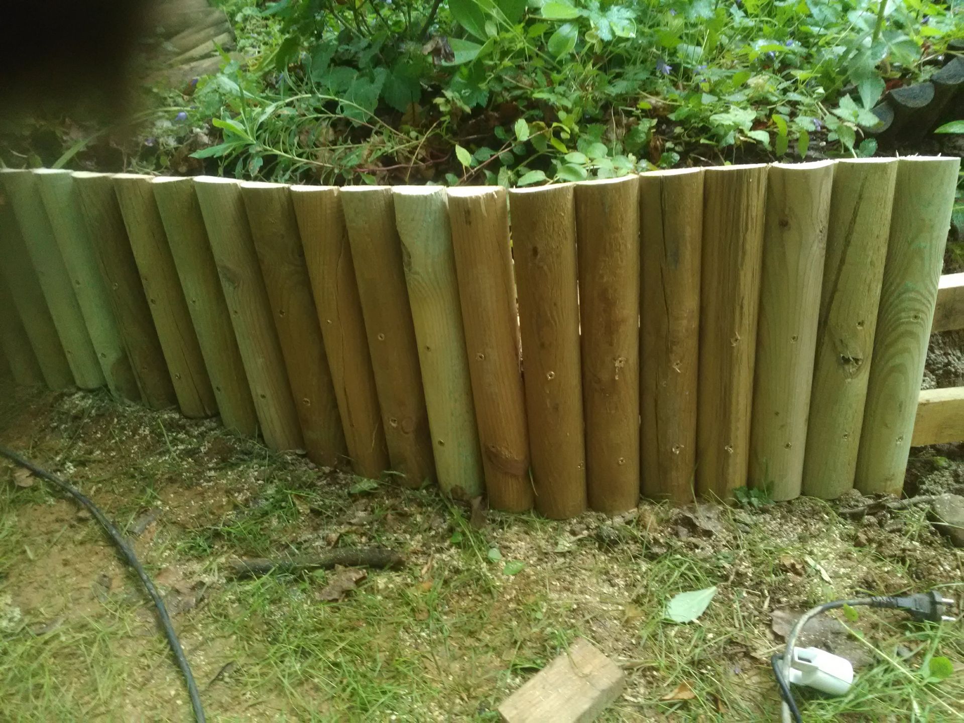 Bordure en rondins de bois dans le parterre de jardin.